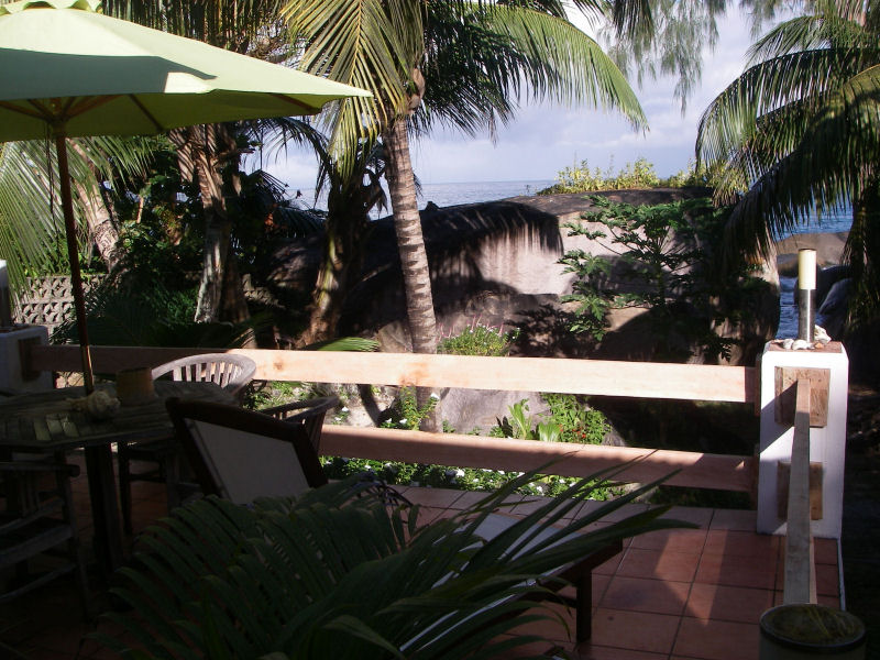 Blick von Terrasse auf Granitfelsen und Palmen